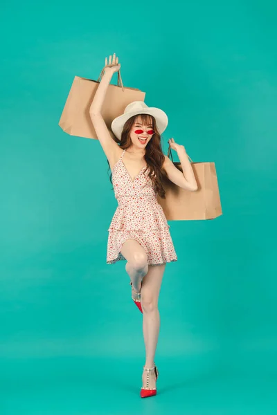 Joyful pretty Asian girl carrying shopping bags with summer dress and enjoys shopping.