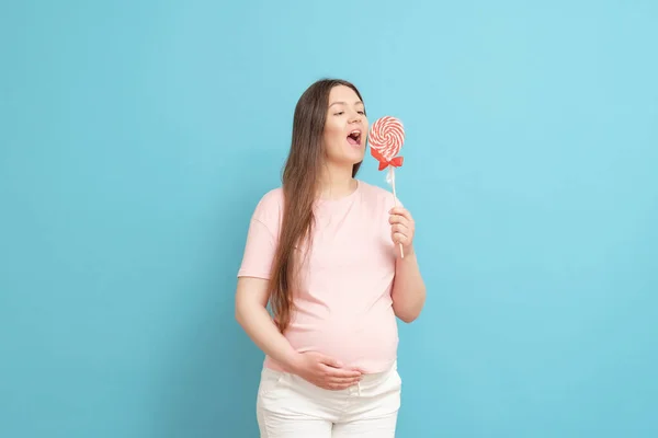 Mavi Arka Planda Pembe Tişörtlü Şeker Düşkünü Mutlu Hamile Bir — Stok fotoğraf