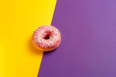 Sarı ve menekşe üzerine pembe çörek koyu mor arka plan görüntüsü 