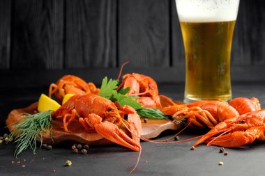 Limonlu ıstakoz ve siyah arka planda kuru biber.