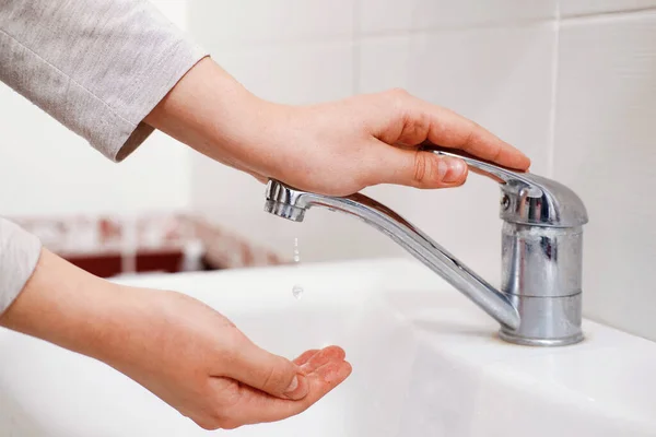 a drop of water from the tap, hands to open the tap water,  the last drop of water from the tap, old water crane