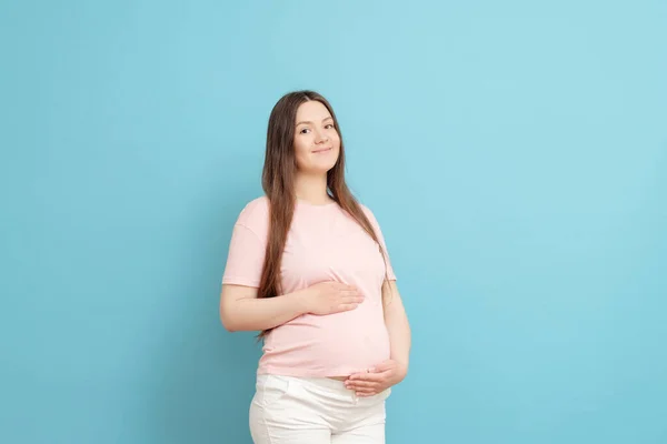 Szczęśliwa Młoda Ciężarna Kobieta Różowej Koszulce Niebieskim Tle — Zdjęcie stockowe