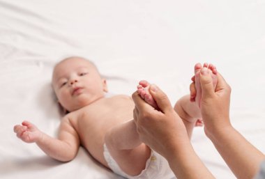bebek ayak masajı, ellerin yakın çekimi ve bebeğin ayağı.