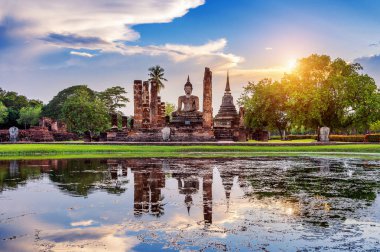 Buddha statue and Wat Mahathat Temple in the precinct of Sukhothai Historical Park, Wat Mahathat Temple is UNESCO World Heritage Site, Thailand. clipart