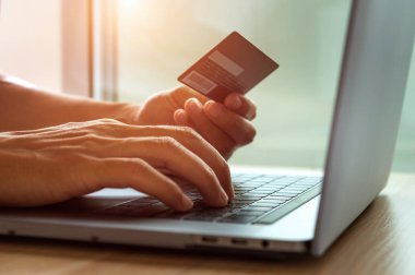 Online alışveriş kavramı. Kredi kartı tutan ve dizüstü bilgisayar kullanan eller. 