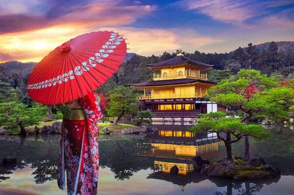 Altın köşkte geleneksel Japon kimonosu giyen Asyalı kadın. Japonya, Kyoto 'daki Kinkakuji Tapınağı.