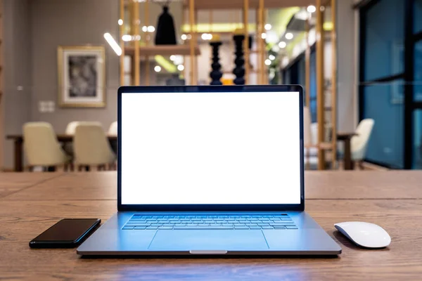 Laptop computer with blank white screen on table. Office concept.