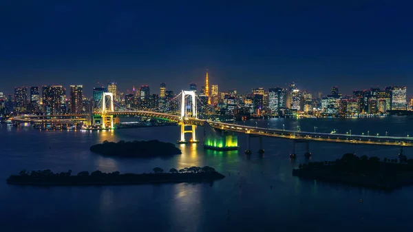 Panorama of tokyo cityscape and rainbow bridge at night.