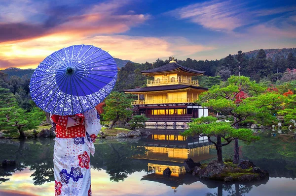 Altın köşkte geleneksel Japon kimonosu giyen Asyalı kadın. Japonya, Kyoto 'daki Kinkakuji Tapınağı.