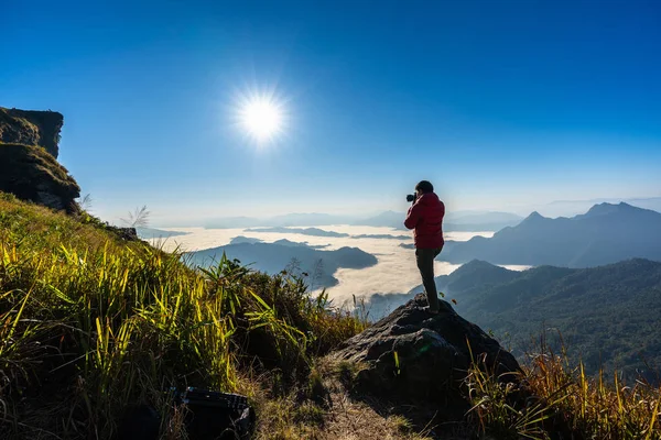 摄影师手拿着相机 站在岩石顶上 旅行概念 — 图库照片