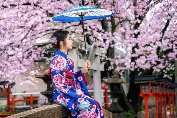 亚洲妇女穿着日本传统和服和樱花在春天，京都寺庙在日本. — 图库照片