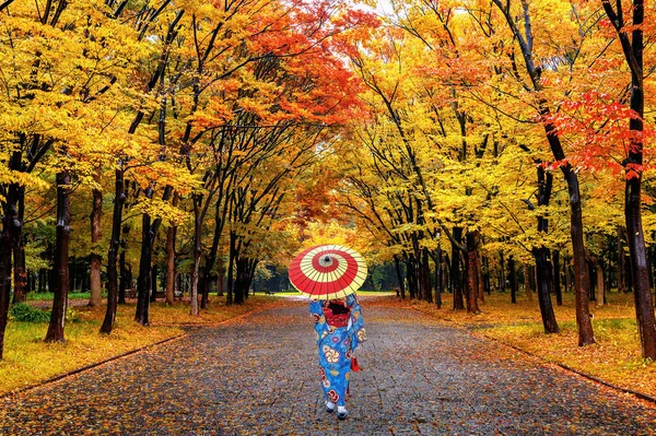 亚洲妇女穿着日本传统和服走在秋天公园. — 图库照片