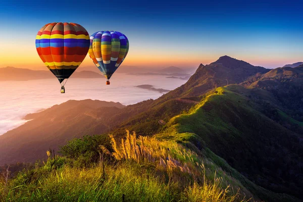 Paisaje de niebla matutina y montañas con globos aerostáticos al amanecer . —  Fotos de Stock