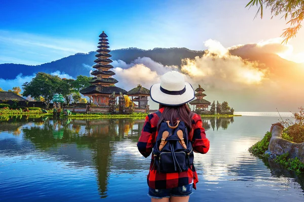 Viajero mujer con mochila buscando pura ulun danu bratan templo en Bali, indonesia . —  Fotos de Stock