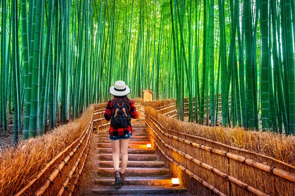 Viajero mujer con mochila caminando en el bosque de bambú en Kyoto, Japón . —  Fotos de Stock