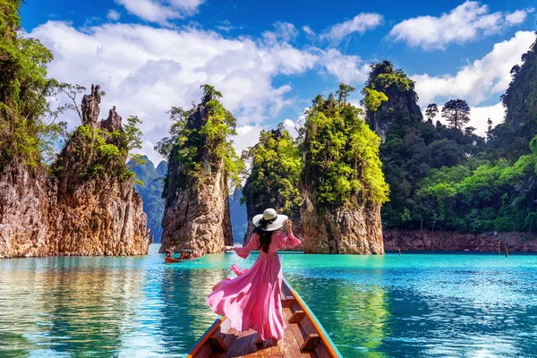 Красивая девушка, стоящая на лодке и смотрящая на горы в плотине Ратчапрафа в Национальном парке Кхао Сок, провинция Сурат Тани, Таиланд . — стоковое фото