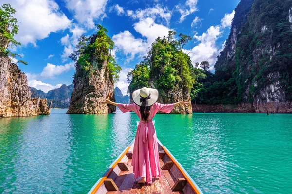 美しい少女がボートの上に立って、タイのスラット・タニー省のカオ・ソック国立公園にあるRatchapha Damで山を探しています. — ストック写真