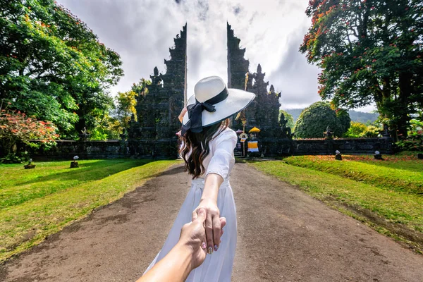 女性観光客は男性の手を握り、バリ島のビッグゲートに彼を導く、インドネシア. — ストック写真