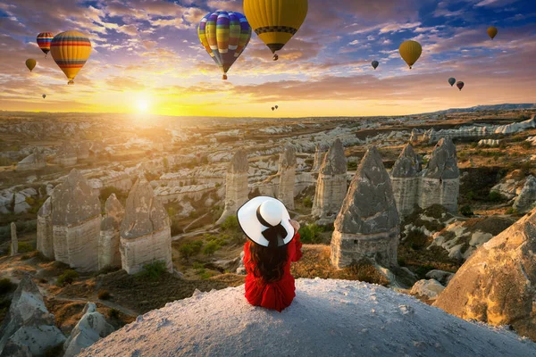 土耳其卡帕多西亚 一名妇女坐在那里观看日出时的热气球 — 图库照片