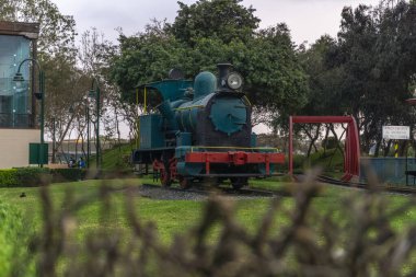 Bir evin yanındaki çimlerin üzerindeki parkta sürmek için küçük tren istasyonu.