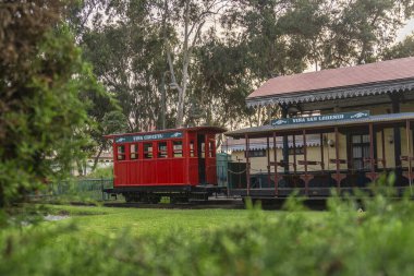 Bir evin yanındaki çimlerin üzerindeki parkta sürmek için küçük tren istasyonu.