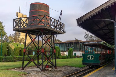 Bir evin yanındaki çimlerin üzerindeki parkta sürmek için küçük tren istasyonu.