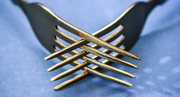 Gümüş takımlar, iki sarı çatal, yakın plan.