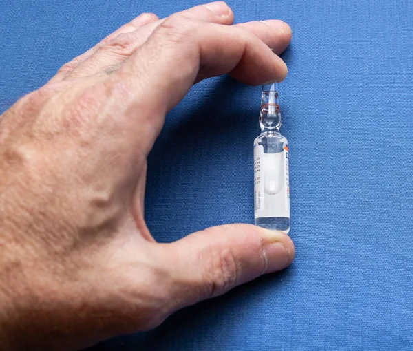 Adamın elindeki tıbbi ampul, ilaç..
