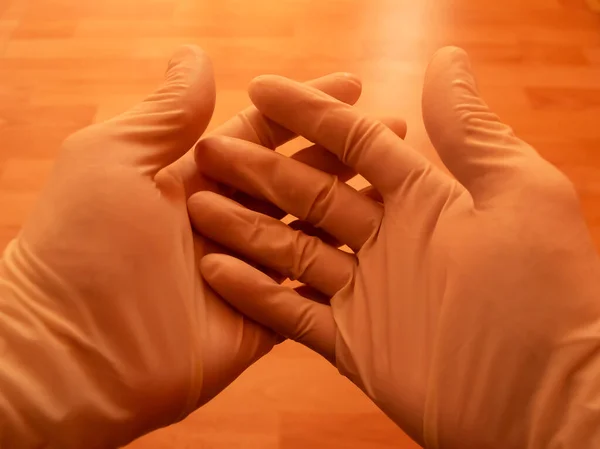 Sarı arka planda tıbbi eldivenleri olan insan eli, virüsü karantinaya alıyor..