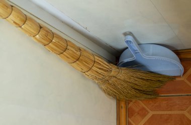 Odanın köşesinde faraşı olan süpürge, odayı temizliyor..