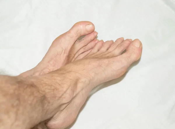 Beyaz havluyla çıplak bir adamın bacakları..