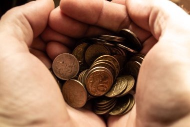 Bir insanın elinde bir sürü sarı para vardır..