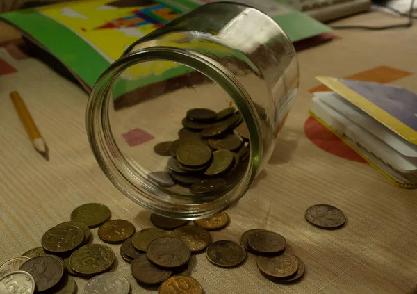 Cam kavanozdan bir sürü sarı para döküldü..