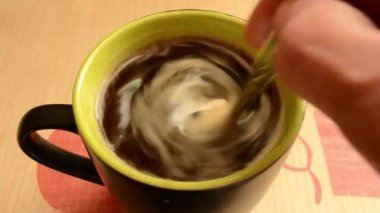 Kahveyi beyaz bir fincanda kaşıkla karıştır..