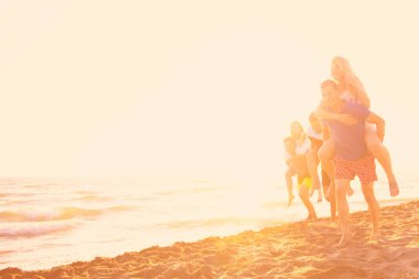 Arkadaşlar eğlence günbatımı güneş ışığı altında sahilde