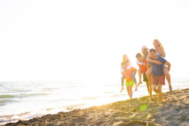 Arkadaşlar eğlence günbatımı güneş ışığı altında sahilde