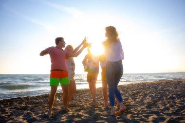 mutlu gençler kumsalda güzel yaz günbatımı üzerinde dans grubu
