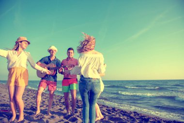 mutlu gençler kumsalda güzel yaz günbatımı üzerinde dans grubu