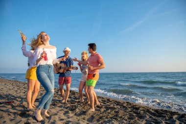 mutlu gençler kumsalda güzel yaz günbatımı üzerinde dans grubu