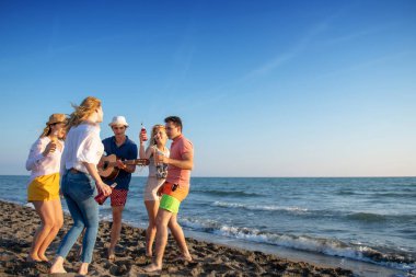mutlu gençler kumsalda güzel yaz günbatımı üzerinde dans grubu