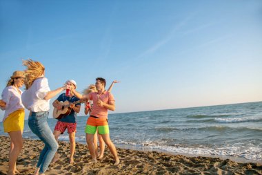 mutlu gençler kumsalda güzel yaz günbatımı üzerinde dans grubu