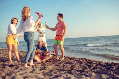 mutlu gençler kumsalda güzel yaz günbatımı üzerinde dans grubu