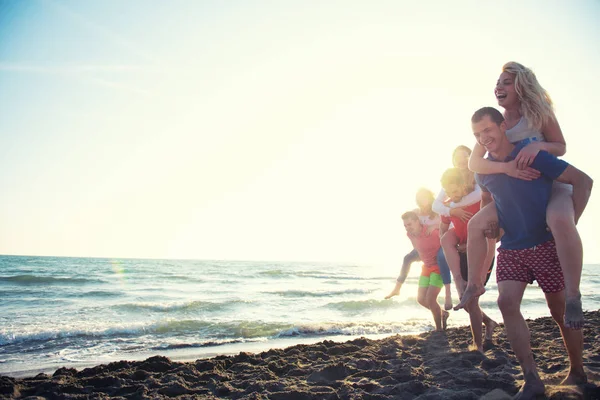 Amici Divertimento Sulla Spiaggia Sotto Luce Del Sole Del Tramonto — Foto Stock