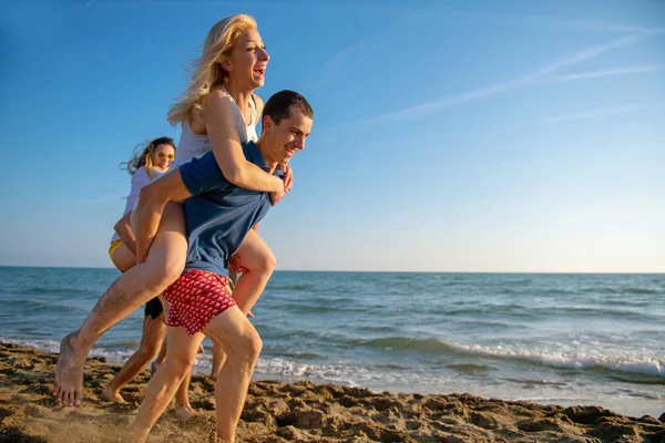 Amici Divertimento Sulla Spiaggia Sotto Luce Del Sole Del Tramonto — Foto Stock