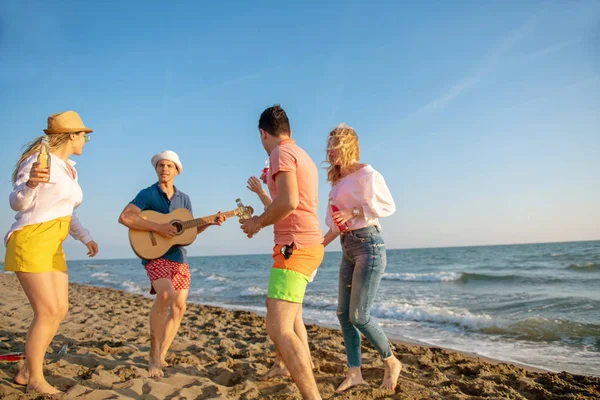 mutlu gençler kumsalda güzel yaz günbatımı üzerinde dans grubu
