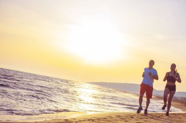 Erkek ve kadın tarafından tropikal plaj günbatımında çalışan önden görünüm