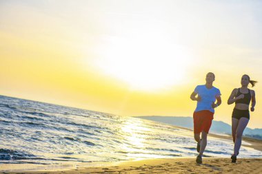 Erkek ve kadın tarafından tropikal plaj günbatımında çalışan önden görünüm