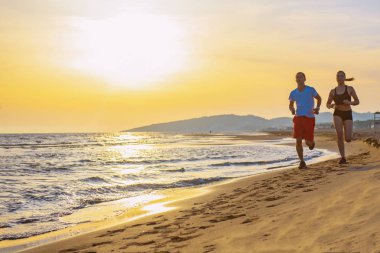 Alt görünümü güzel çiftin tropik sahilde koşu