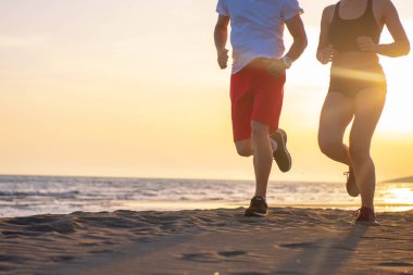 Genç çiftin birlikte tropikal deniz kenarında günbatımında çalışan zemin görünümü