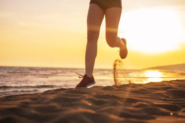 Plajda gündoğumu gökyüzü karşı çalışan kadın düşük bölüm görünümü